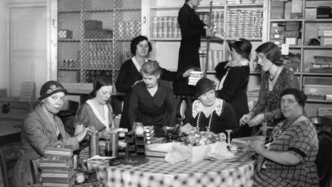 Photo en noir et blanc datant des année 50 avec des bénévoles dans un salon de thé