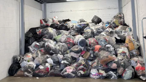 Des sacs de vêtements dans un hangar