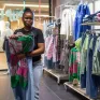 une jeune dans une boutique de vêtements conseillant un client